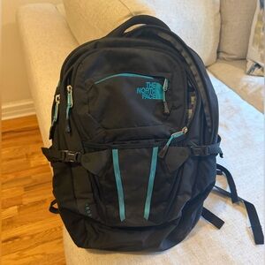 The North Face ReCon Black Backpack with Teal Accents and Multiple Pockets